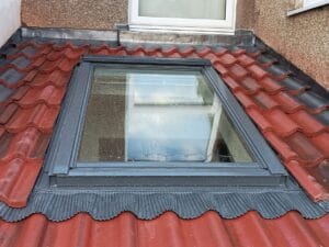 velux window on red tile roof