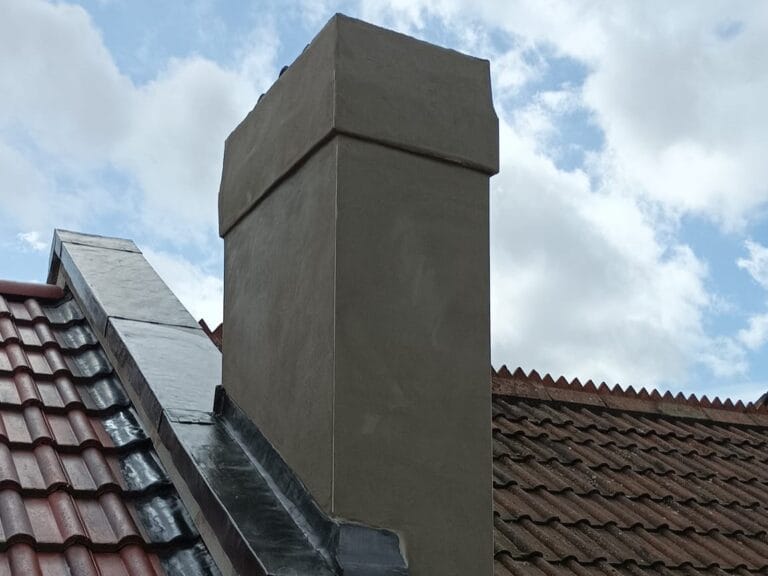 Newly fitted lead flashing around chimney base on a tiled pitched roof in Bristol, ensuring watertight sealing and weather resistance.