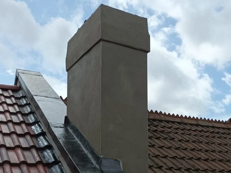 Newly fitted lead flashing around chimney base on a tiled pitched roof in Bristol, ensuring watertight sealing and weather resistance.
