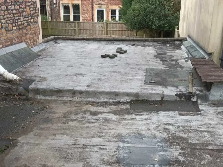 Damaged EPDM flat roof with visible wear and surface defects